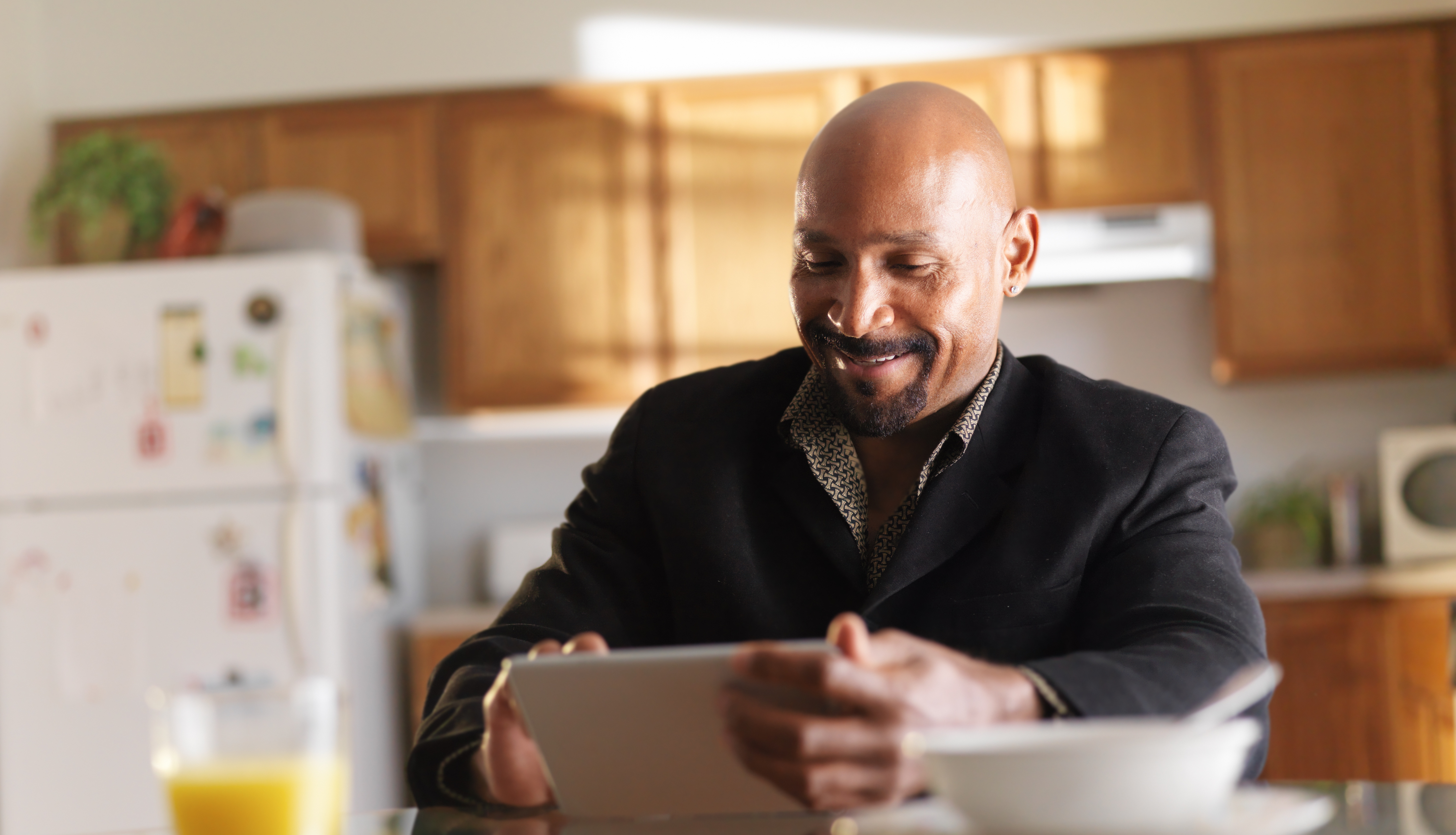 middle aged man in kitchen on tablet